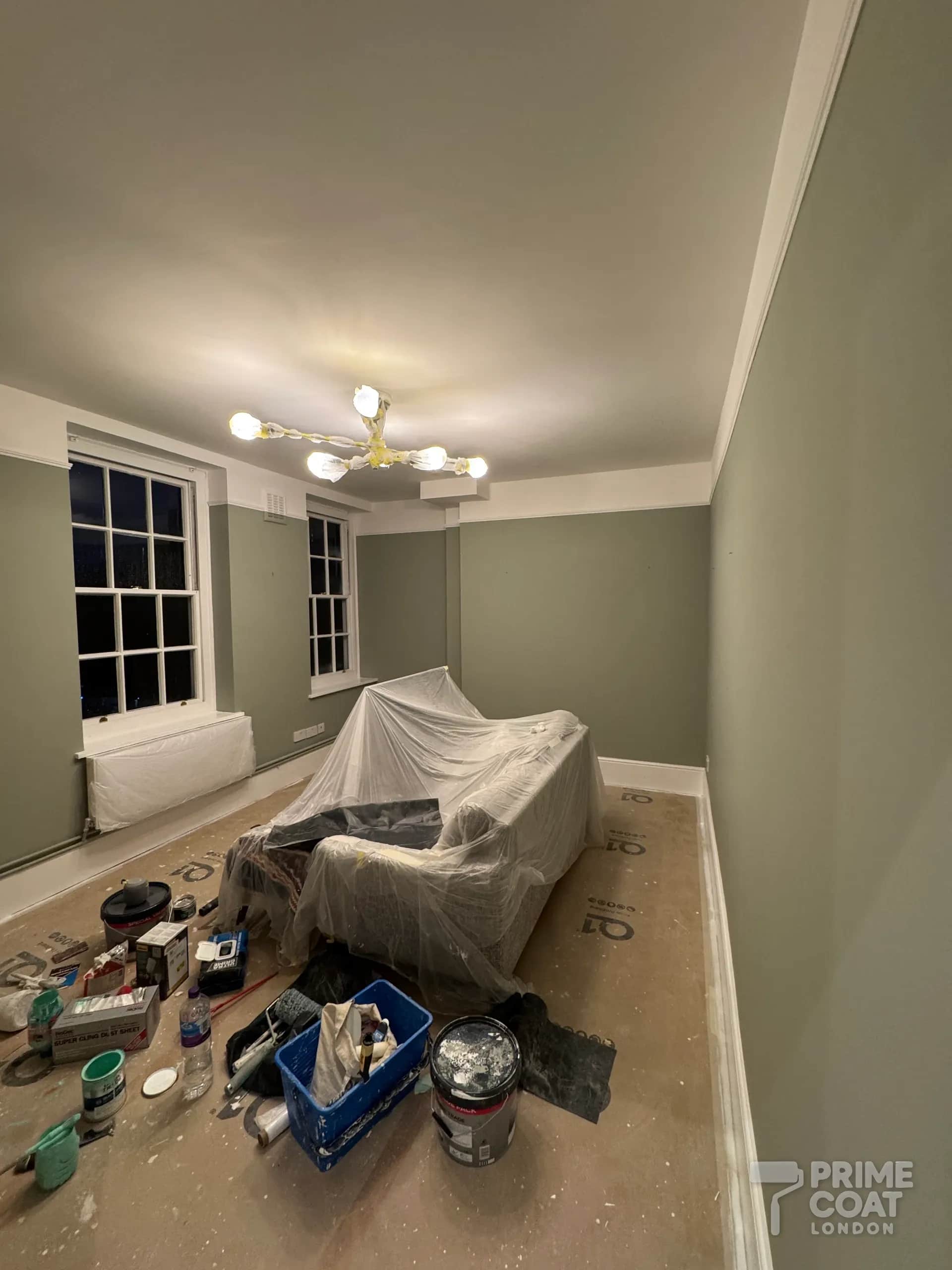 Battersea SW11 period flat living room after repainting — repaired ceiling and freshly painted green-grey walls under a white cornice