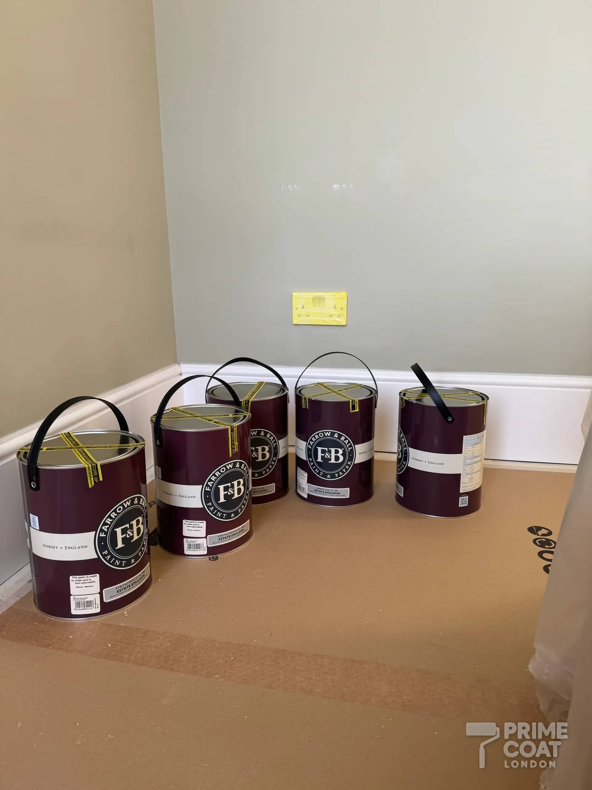 Farrow & Ball Estate Emulsion tins — Strong White, Blue Gray and Ammonite — on Q1 floor protection in a Battersea SW11 flat