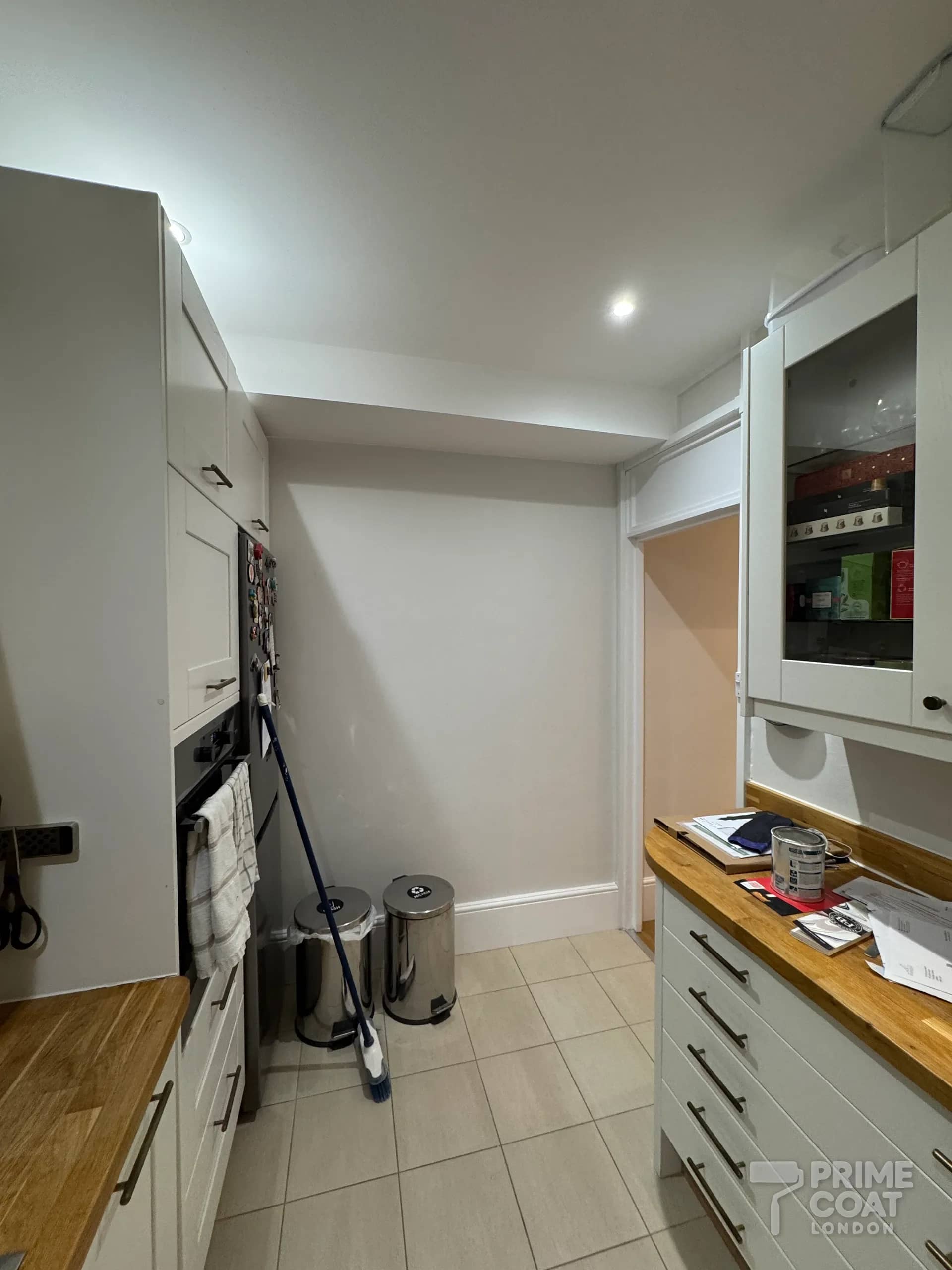 Kitchen of a Battersea SW11 period flat after repainting — freshly painted walls around the units and fridge